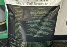 A bag of mix soil sitting on top of a floor.